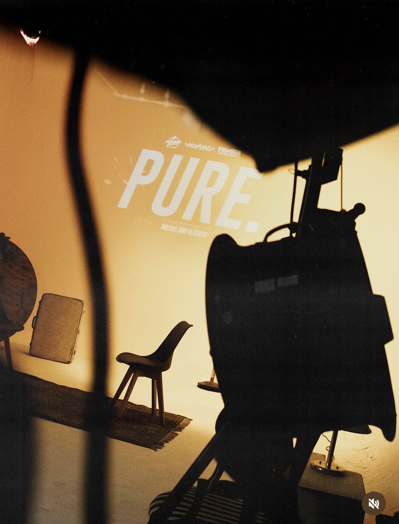 Set del progetto PURE: logo proiettato su fondale e sagoma di una cinepresa
